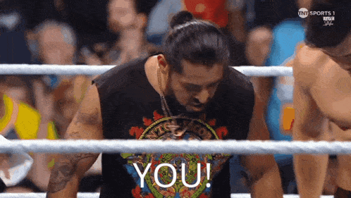a man in a wrestling ring with the word you on his shirt