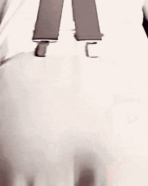a person wearing suspenders has a pink circle drawn on their butt