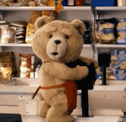 a teddy bear wearing an apron is holding a bag of doritos chips