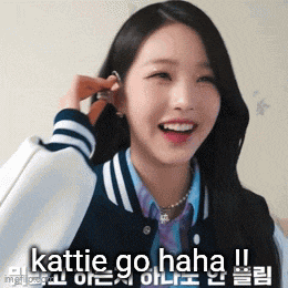 a girl in a varsity jacket is smiling and talking on a cell phone