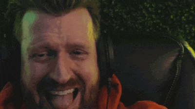 a man with a beard and headphones is sticking his tongue out .