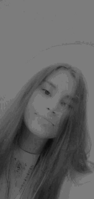 a black and white photo of a girl 's face with long hair .