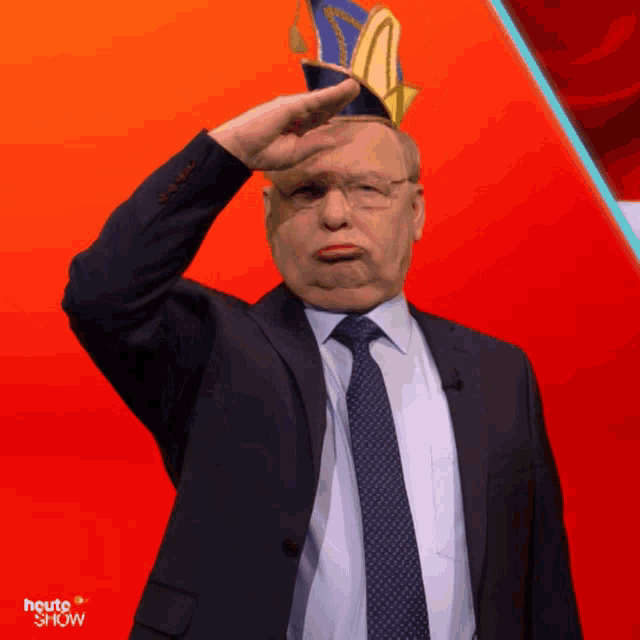 a man in a suit and tie is saluting in front of a red background that says " heute show "