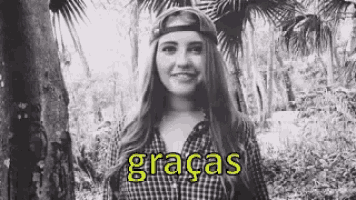 a black and white photo of a woman wearing a plaid shirt and a hat .