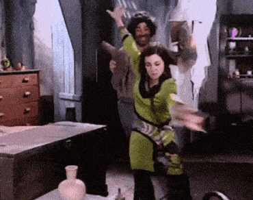 a woman in a green outfit is dancing with a man