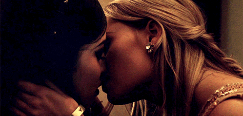 two women are kissing in front of a mirror with the letters x and y on it