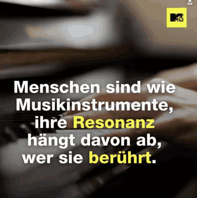 a black and white photo of a person playing a piano with a yellow mtv logo in the corner