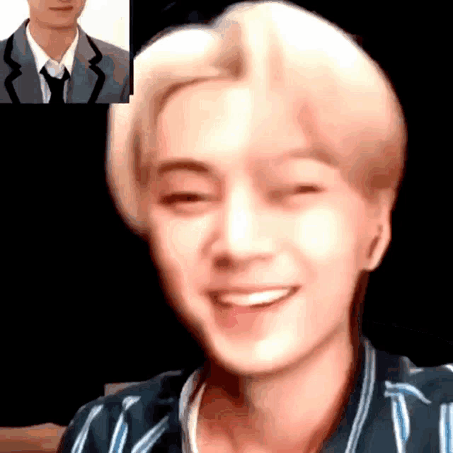 a man in a suit and tie is smiling in front of another man