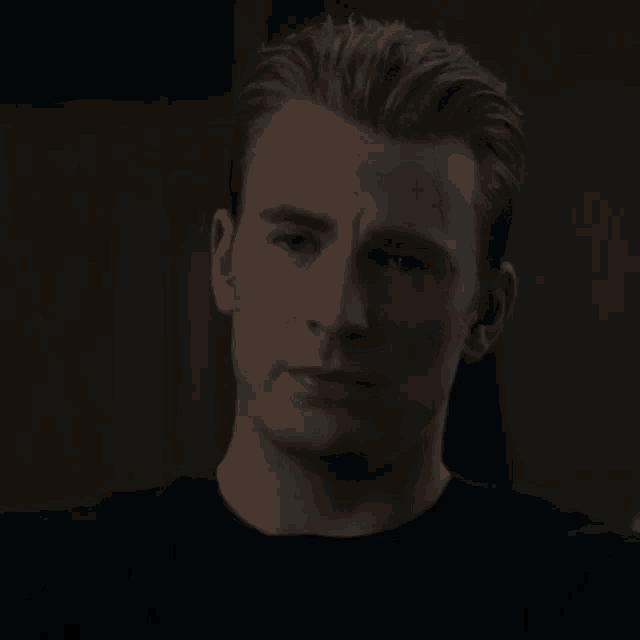 a close up of a man 's face with a black shirt on