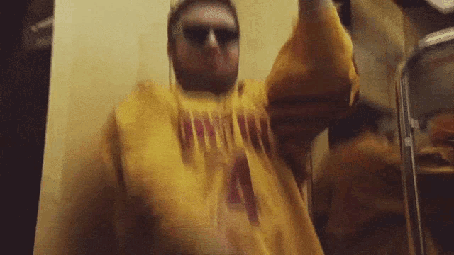 a man wearing a yellow sweatshirt that says thrasher