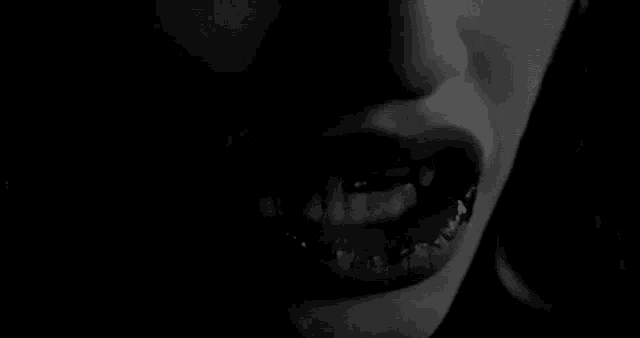 a close up of a woman 's mouth and teeth in a black and white photo
