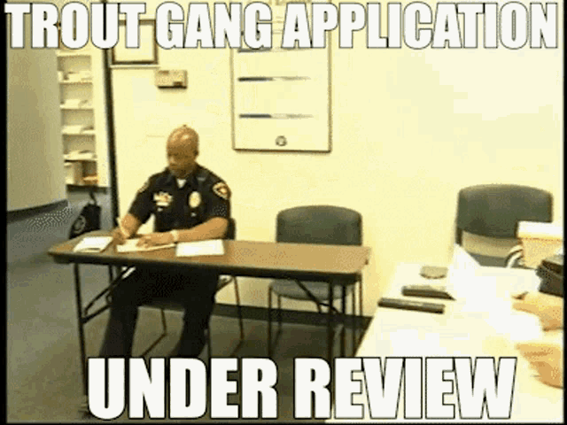 a police officer sits at a desk with the words trout gang application under review on the bottom