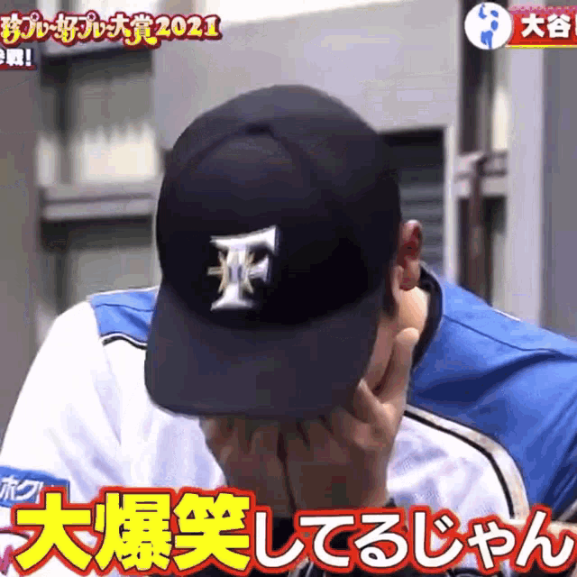 a man wearing a baseball cap with the letter f on it covering his face