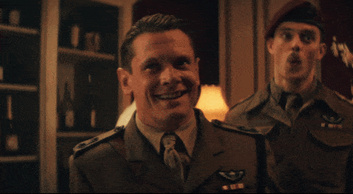 a man in a military uniform is smiling and looking at the camera