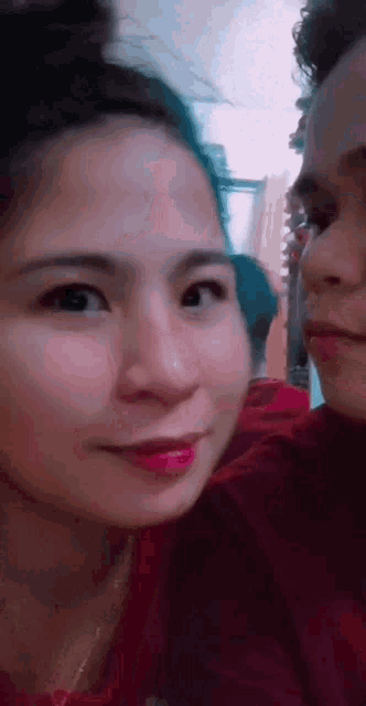 a man and a woman are looking at each other . the woman is wearing red lipstick .