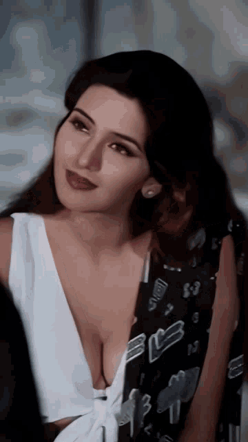 a woman with a very plunging neckline is wearing a black and white shirt with the letter b on it