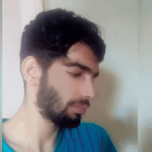 a man with a beard and a blue shirt is looking down