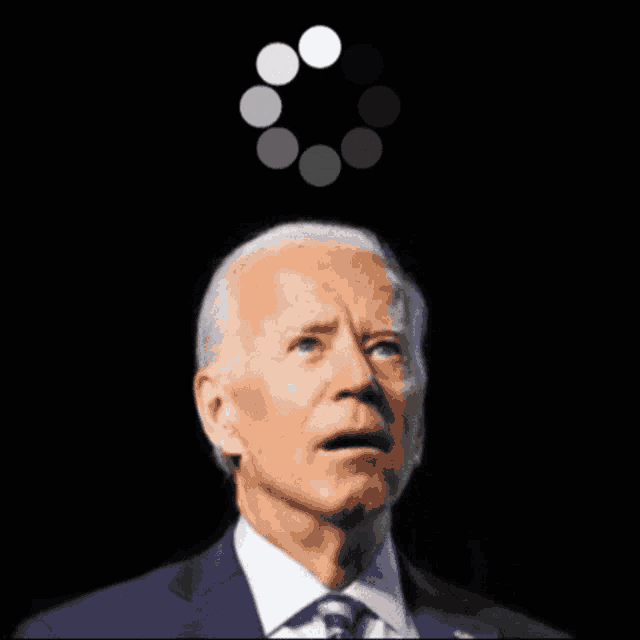 a man in a suit and tie is looking up at a loading circle