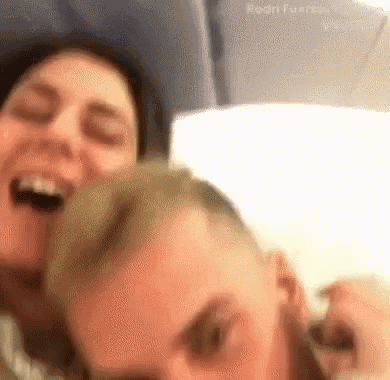a man and a woman are taking a selfie on a plane .