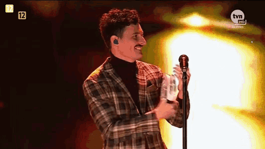 a man singing into a microphone with the tvn logo in the corner