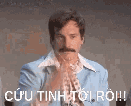 a man with a mustache is wearing a blue jacket and a scarf and is making a funny face .