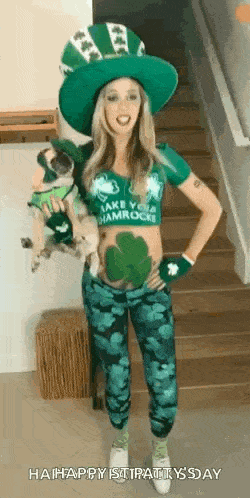 a woman in a leprechaun costume is holding a small dog and standing on a set of stairs .
