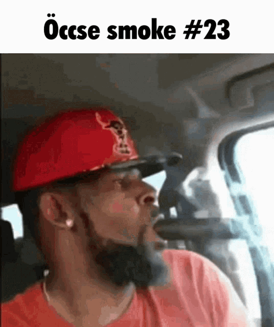 a man wearing a red hat is smoking a cigarette