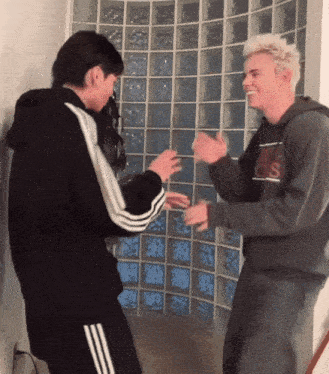 a man wearing a hoodie that says nike on it is dancing with another man