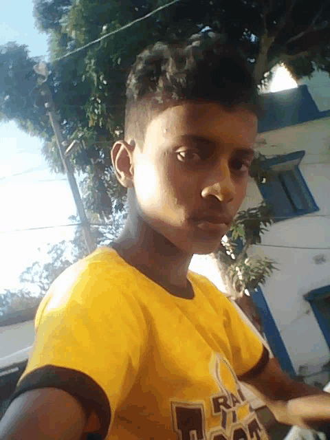 a young man wearing a yellow t-shirt that says ' rn ' on it