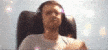 a man is sitting in a chair wearing headphones and looking at the camera .