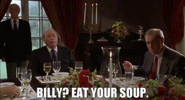a group of men are sitting at a table with the words billy ? eat your soup .