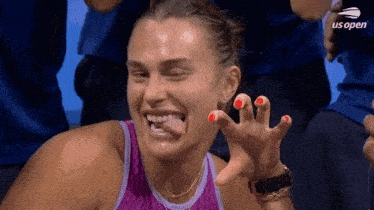 a woman in a purple tank top is making a funny face at the us open tennis tournament