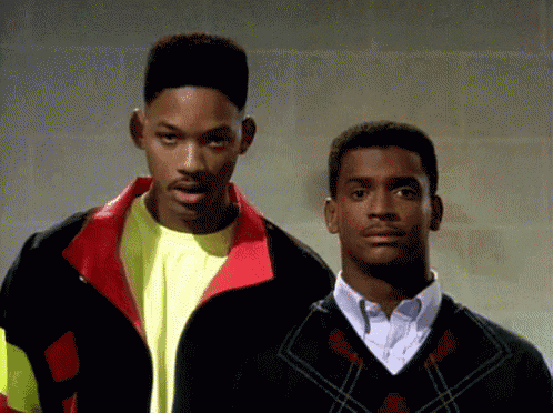 two men are standing next to each other and one is wearing a plaid sweater