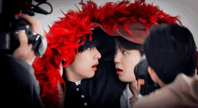 a person wearing a red feathered hat is being photographed by another person