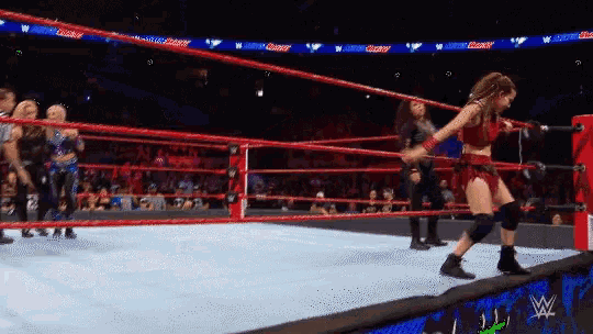 a woman in a wrestling ring with a w logo