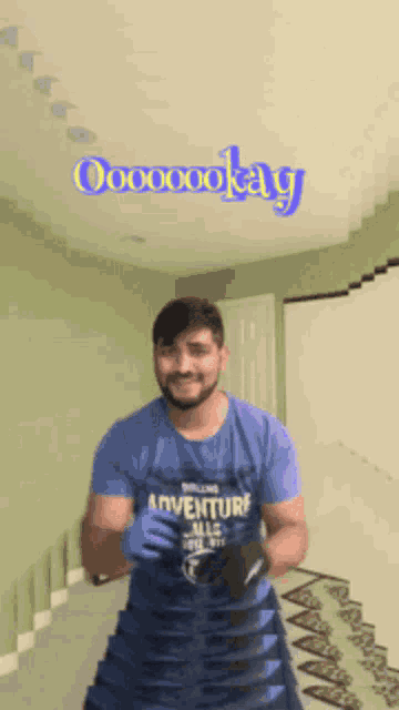 a man wearing a blue shirt that says adventure all along