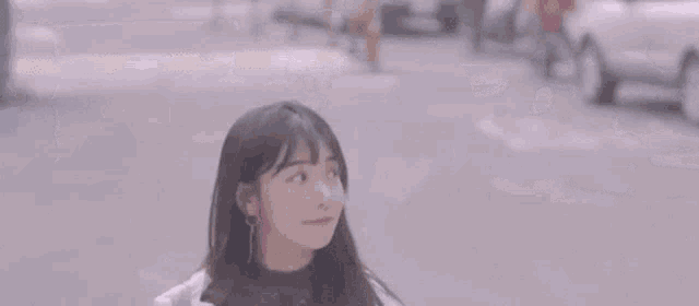 a young woman is walking down a city street and smiling at the camera .