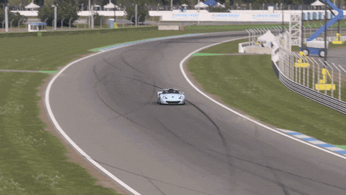 a white race car is driving on a track