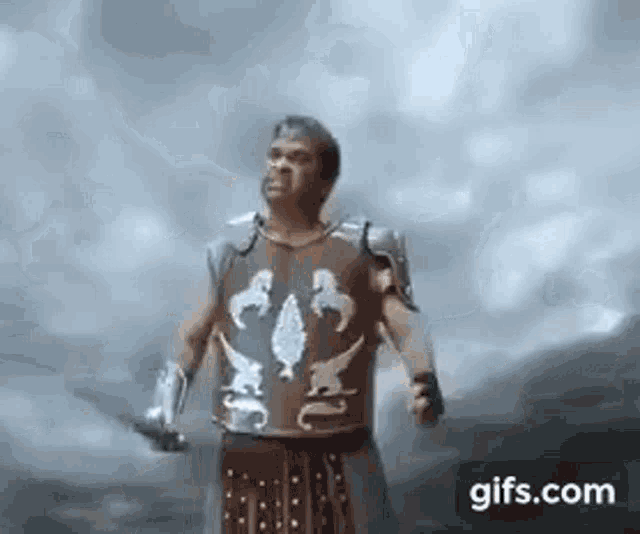 a man in a gladiator costume is holding a sword .