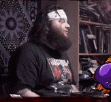 a man with a bandage on his head is wearing a black shirt that says ' heavy metal ' on it