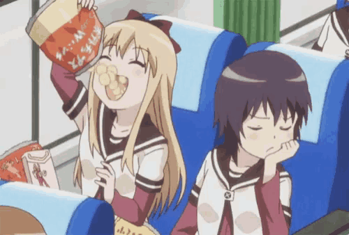 a girl is eating a bag of chips while another girl sits in a chair