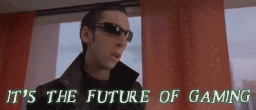 a man wearing sunglasses is standing in front of a window and says it 's the future of gaming .