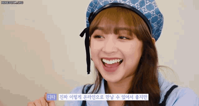 a woman wearing a blue hat with a gucci logo on it smiles