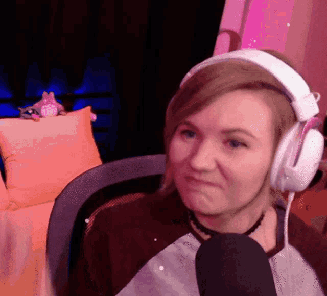a woman wearing headphones and a microphone making a funny face