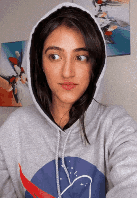 a woman wearing a nasa hoodie takes a picture of herself