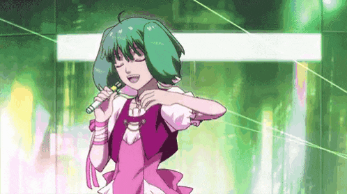 a girl in a pink dress is singing into a microphone while standing in front of a green background .