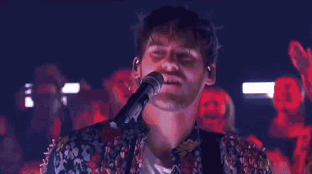 a man is singing into a microphone on a stage