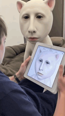 a man is holding a tablet with a picture of a cat face on it