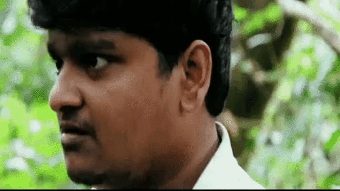 a man in a white shirt is looking at the camera with a green background .