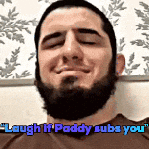 a man with a beard is smiling with the words " laugh if paddy subs you " above him